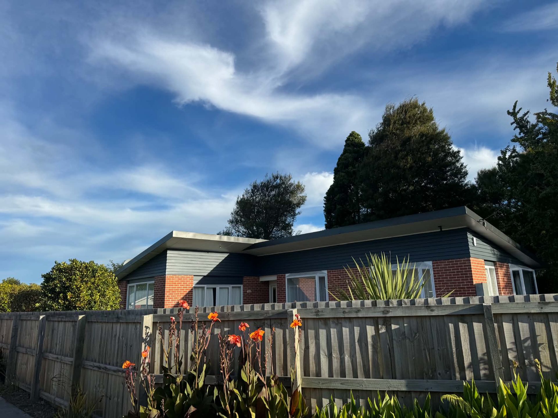 Repainted blue weatherboard and brick house exterior