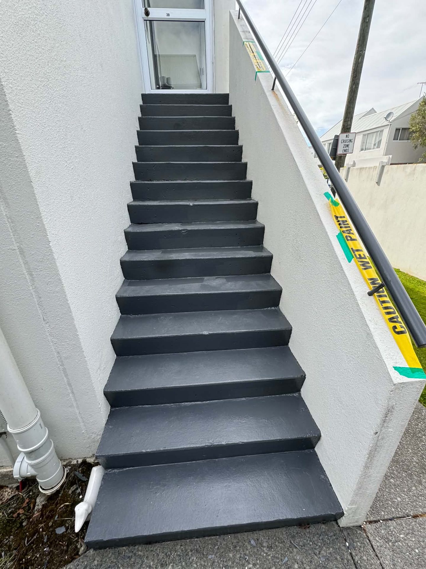 Charcoal-painted exterior access stairs alongside a house