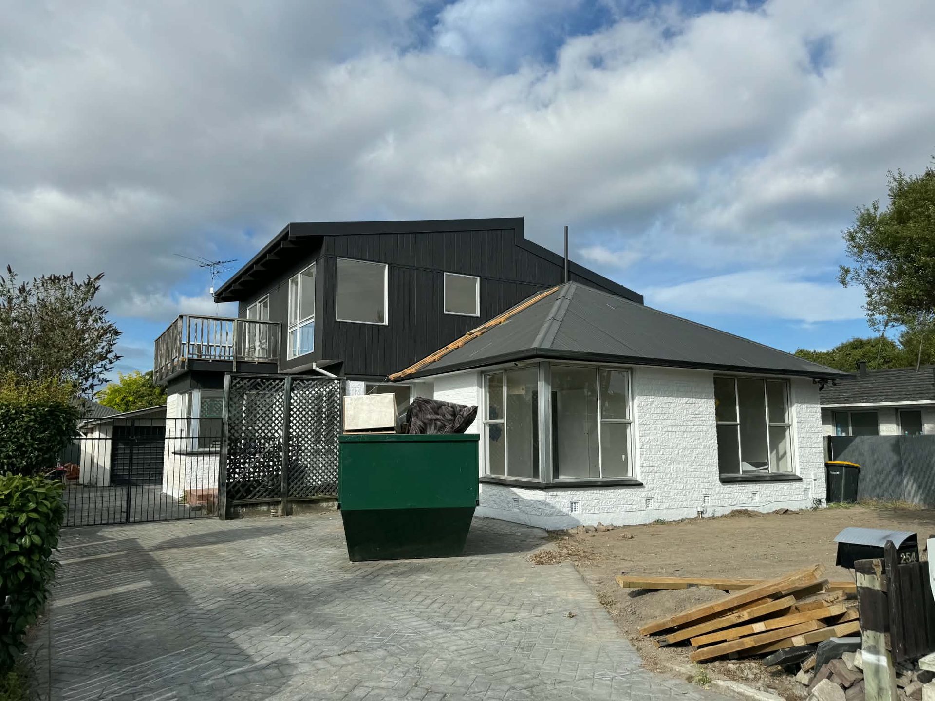 Black and white repainted house exterior with driveway